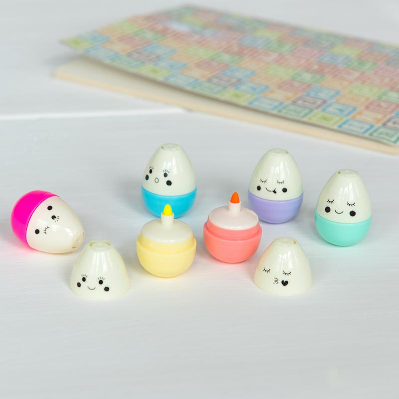 Egg pens on a table, four closed and two open, showing the highlighter nibs. 